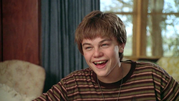 Ein junger, lachender Leonardo DiCaprio mit braun gestreiftem T-Shirt.