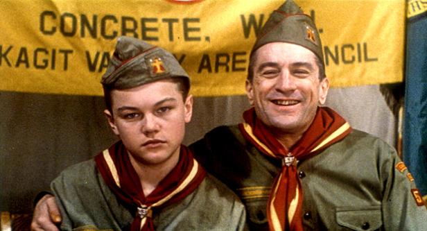 Leonardo DiCaprio und Robert De Niro in Pfadfinderuniformen vor einem Banner.