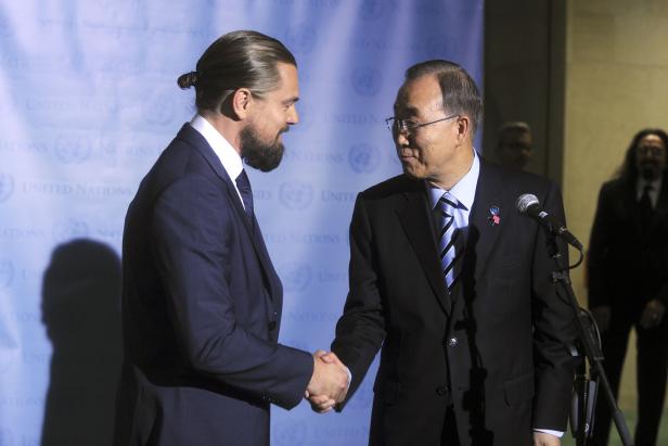 Leonardo DiCaprio schüttelt Ban Ki-moon vor einem UN-Hintergrund die Hand.