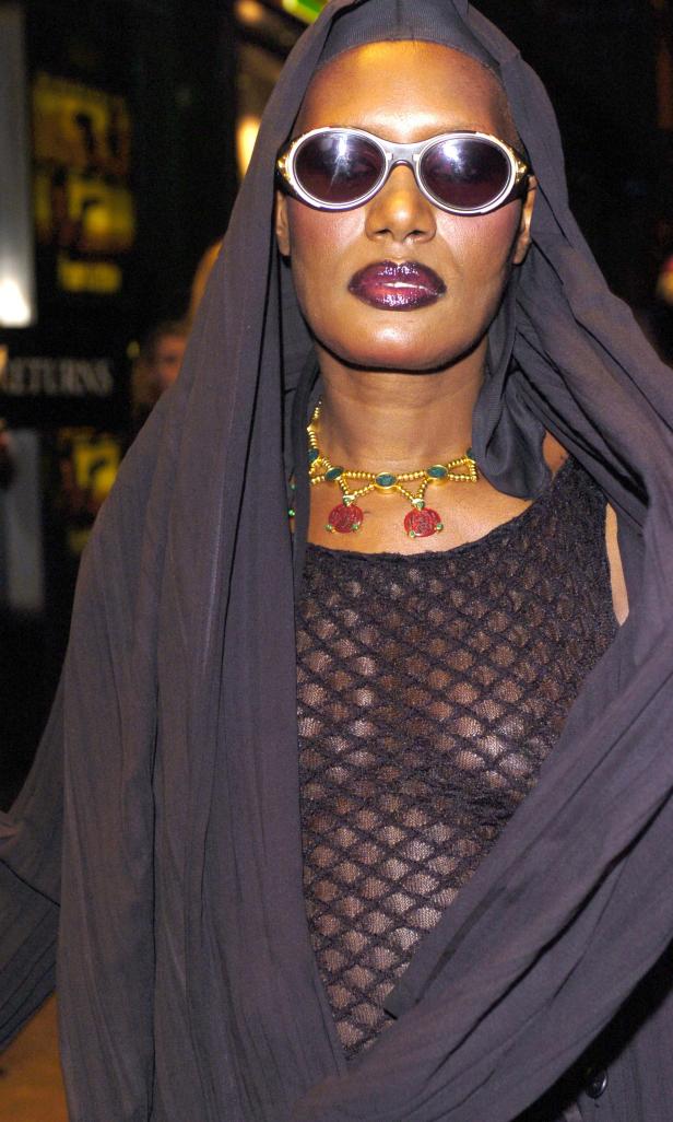 Grace Jones mit Sonnenbrille und Kapuze bei einer Veranstaltung.