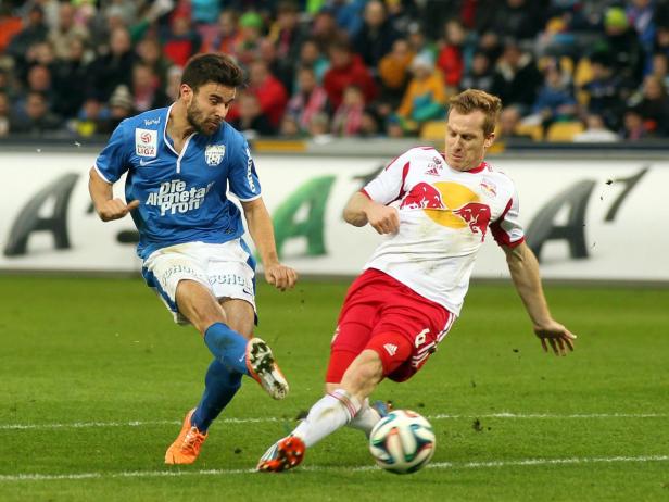 Zwei Fußballspieler kämpfen um den Ball auf dem Spielfeld.