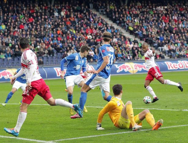 Fußballspieler in Aktion während eines Spiels vor einer Zuschauermenge.