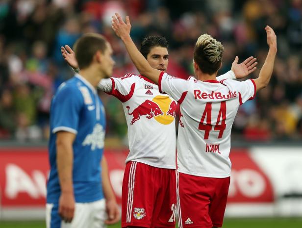 Zwei Fußballspieler von Red Bull jubeln mit erhobenen Armen.