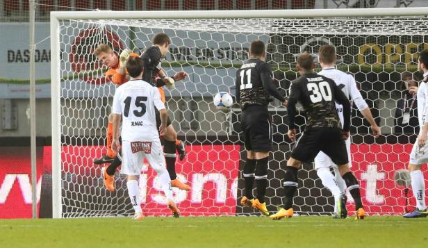 Ein Fußballspiel mit mehreren Spielern vor einem Tor.