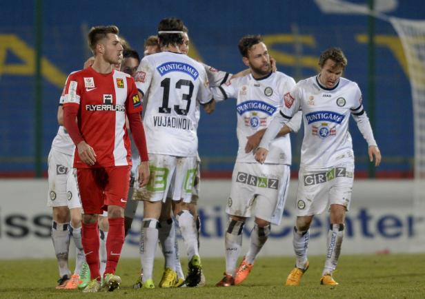 Fußballspieler von zwei verschiedenen Mannschaften stehen auf dem Spielfeld.