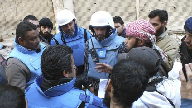 Eine Gruppe von Personen, darunter einige mit Helmen und Westen des Welternährungsprogramms (WFP), stehen zusammen.