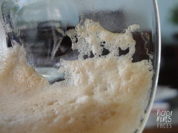 Nahaufnahme eines Glases mit schaumigem Getränk.