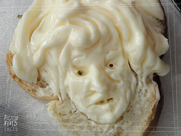 Ein Gesicht aus Mayonnaise auf einer Scheibe Brot geformt.
