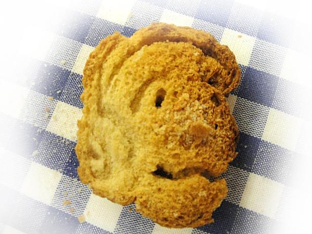 Ein Cantuccio liegt auf einem blau-weiß karierten Tuch.