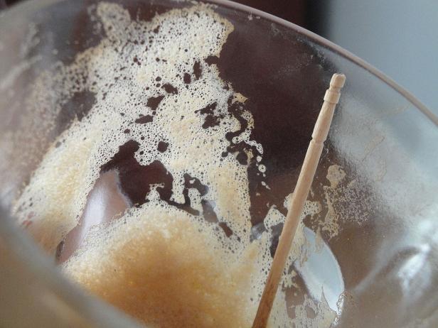 Ein Glas mit einem Getränk und einem Holzstäbchen darin.