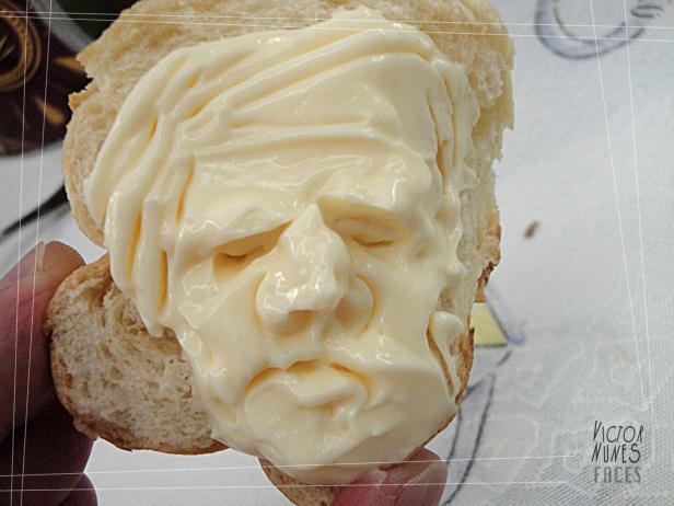 Ein Gesicht aus Mayonnaise auf einem Stück Brot.