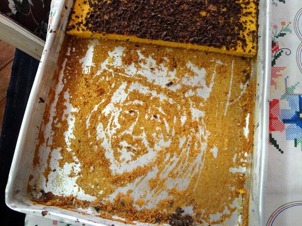 Ein fast leerer Kuchenblech mit Krümeln und einem kleinen Stück Kuchen mit Schokoladenstreuseln.