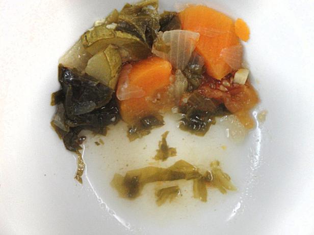 Gemischtes Gemüse, darunter Karotten und Kohl, in einer weißen Schüssel.