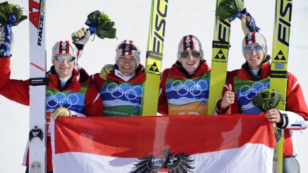 Österreichische Skispringer feiern mit der österreichischen Flagge bei den Olympischen Spielen in Vancouver 2010.