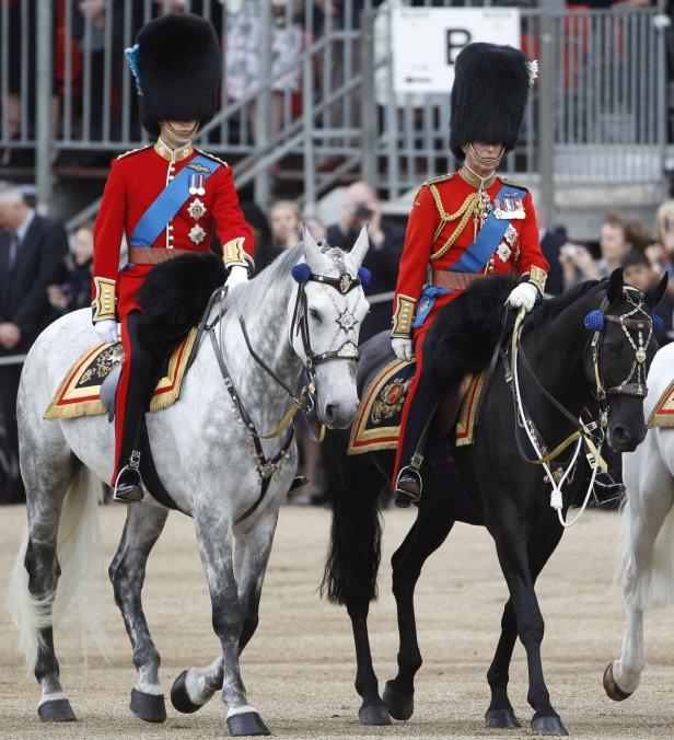 Zwei Gardesoldaten in roter Uniform reiten auf Pferden.