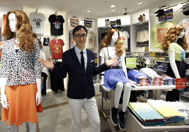 Ein Mann in einem Bekleidungsgeschäft, umgeben von Schaufensterpuppen und T-Shirts.