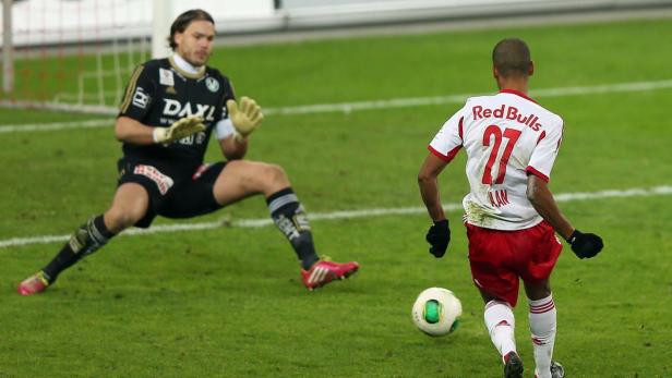 Ein Fußballspieler von Red Bull schießt auf das Tor, das von einem Torwart verteidigt wird.