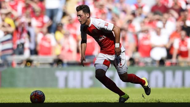 Mesut Özil beim Fußballspiel im Trikot des FC Arsenal mit einem Ball am Fuß.