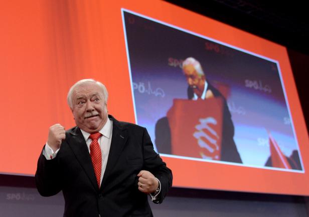 Ein Mann im Anzug ballt die Faust vor einem Bildschirm mit einem Redner der SPÖ.