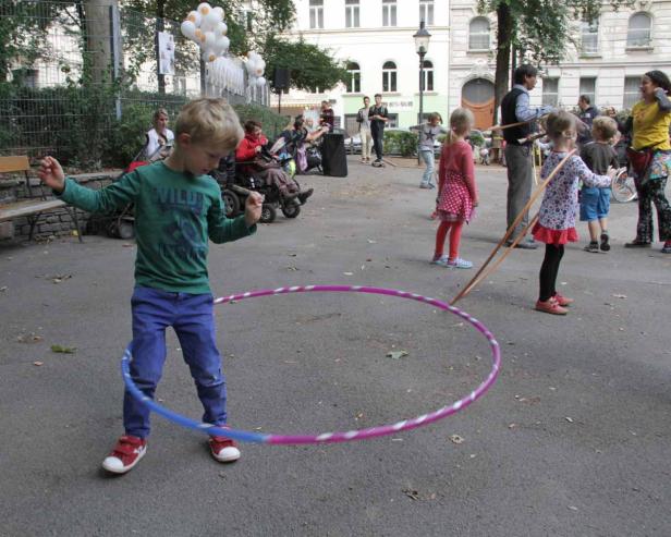 Ein Junge spielt mit einem Hula-Hoop-Reifen in einem Park.