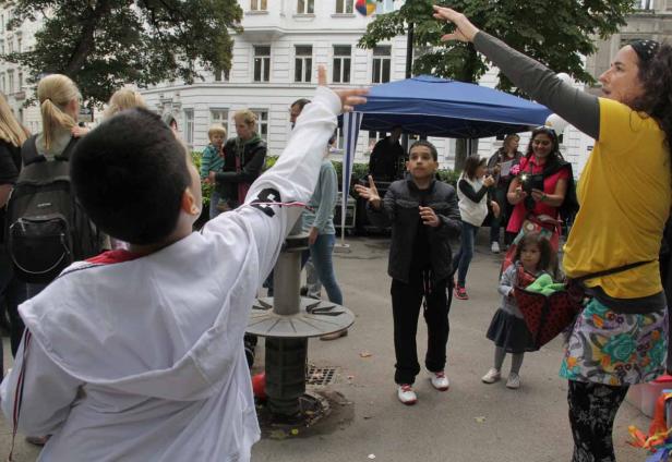 Kinder spielen mit einem Ball auf einer öffentlichen Veranstaltung im Freien.