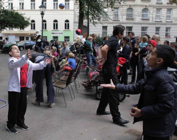 Eine Gruppe von Menschen, darunter Kinder, versammelt sich im Freien.