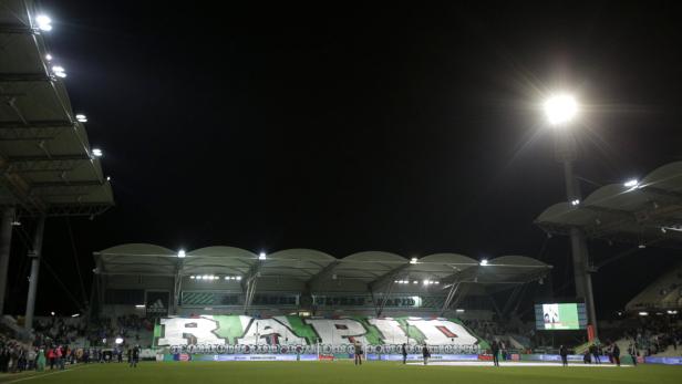 Ein Fußballstadion mit einem großen Banner, das „Rapid“ zeigt.