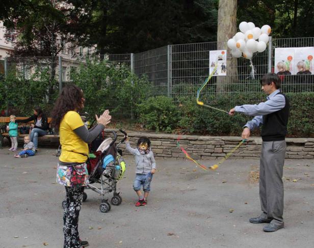 Ein Mann führt auf einer Veranstaltung im Freien eine Tanzvorführung mit Bändern für Kinder auf.