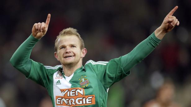 Ein Fußballspieler von Rapid Wien jubelt mit erhobenen Armen.