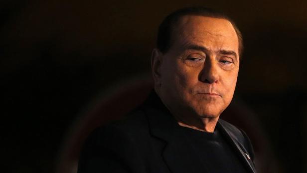 Ein Porträt von Silvio Berlusconi vor einem dunklen Hintergrund.