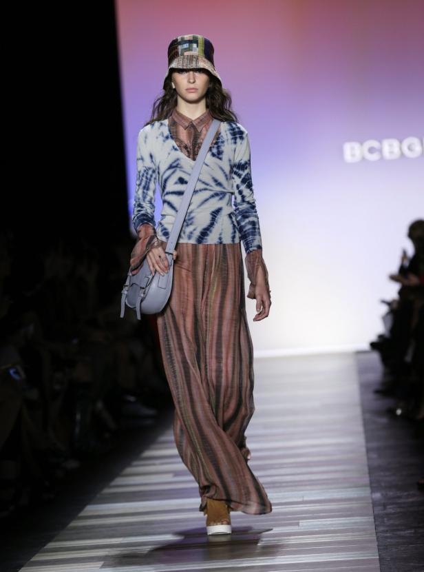 Eine Frau in einem farbenfrohen Outfit läuft auf einem Laufsteg.