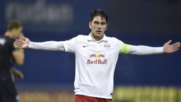 Ein Fußballspieler von Red Bull mit ausgebreiteten Armen auf dem Spielfeld.