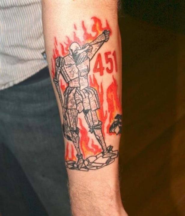 Ein Tattoo auf einem Arm zeigt eine stilisierte Figur in Flammen mit der Zahl 451.
