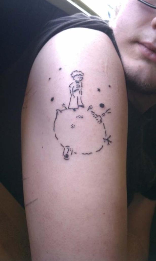Ein Tattoo auf einem Arm zeigt den kleinen Prinzen auf seinem Asteroiden.