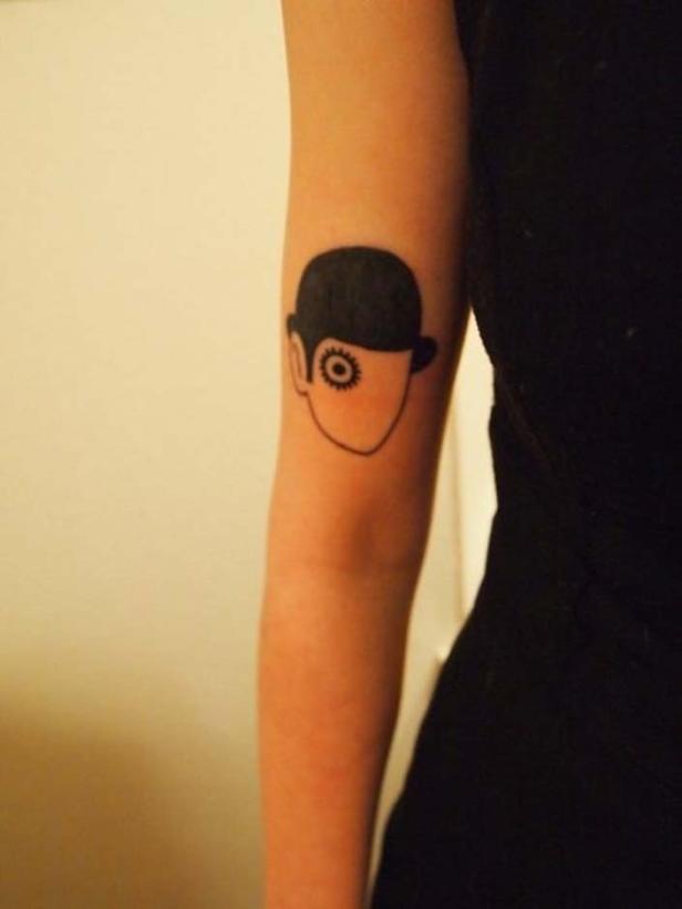 Ein Tattoo auf einem Arm zeigt eine stilisierte Figur aus „Uhrwerk Orange“.