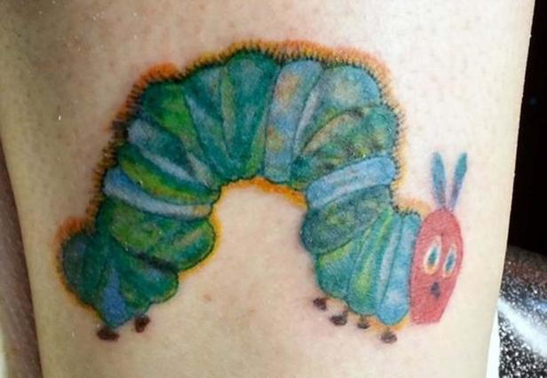 Ein Tattoo einer bunten Raupe auf heller Haut.