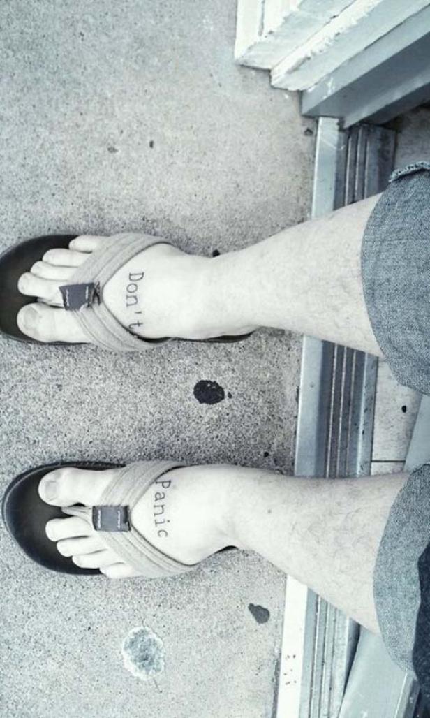 Ein Mann trägt Sandalen mit der Aufschrift „Don't Panic“.