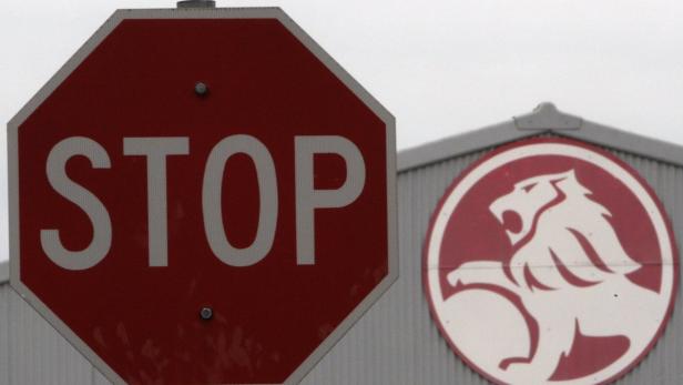 Ein Stoppschild vor einem Gebäude mit dem Logo von Holden.