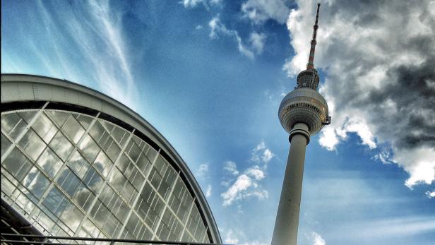 Der Berliner Fernsehturm und ein Teil des Hauptbahnhofs unter blauem Himmel.
