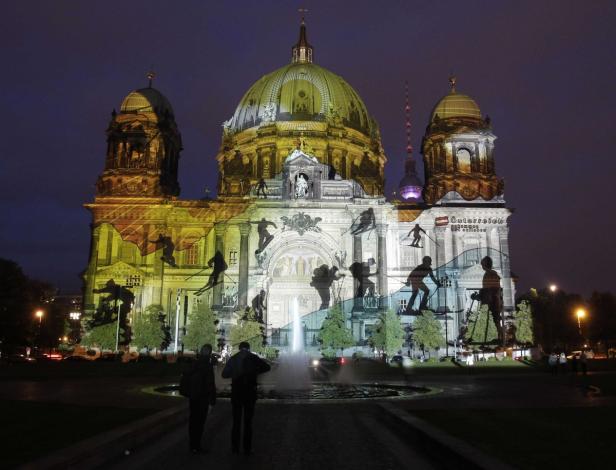 Der Berliner Dom ist nachts mit Skifahrern und dem Schriftzug „Österreich“ beleuchtet.