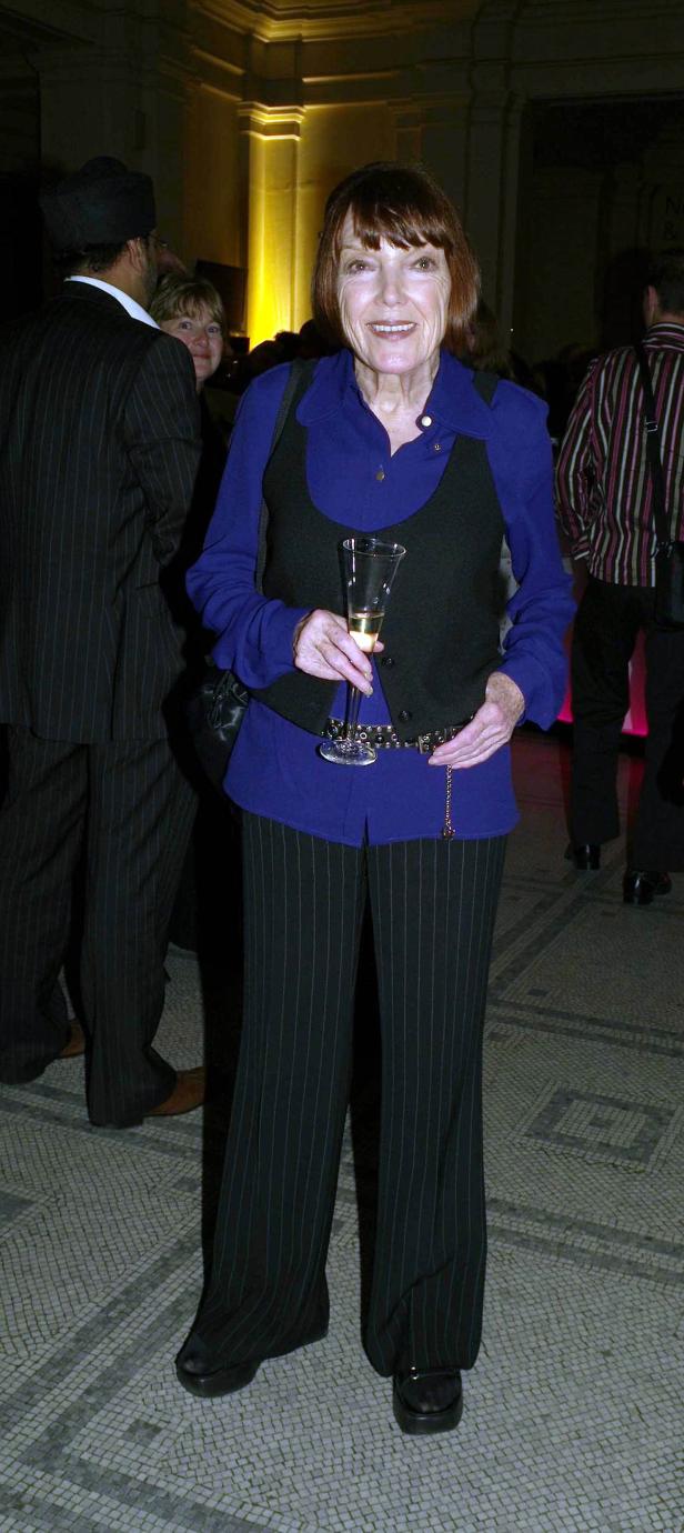 Eine Frau mit einem Glas Sekt auf einer Veranstaltung.