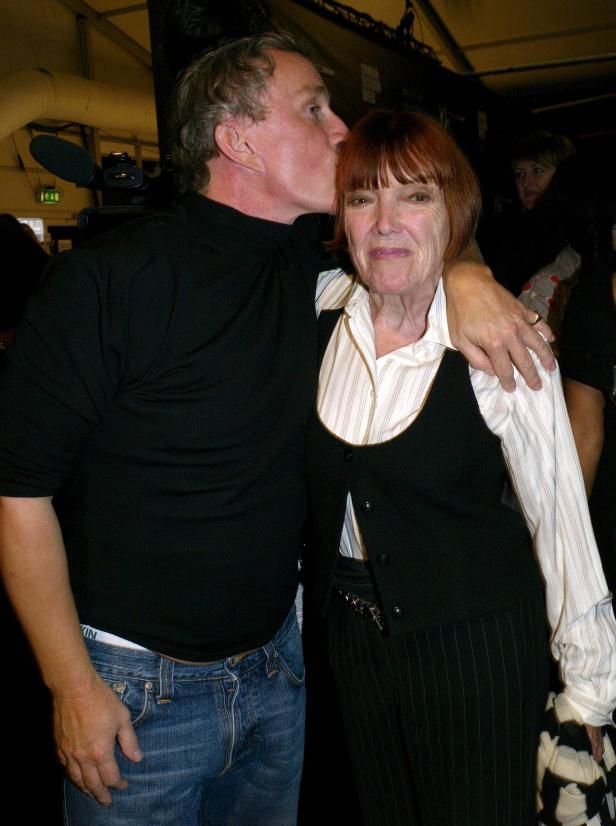 Ein Mann gibt einer Frau mit roten Haaren einen Kuss auf die Stirn.