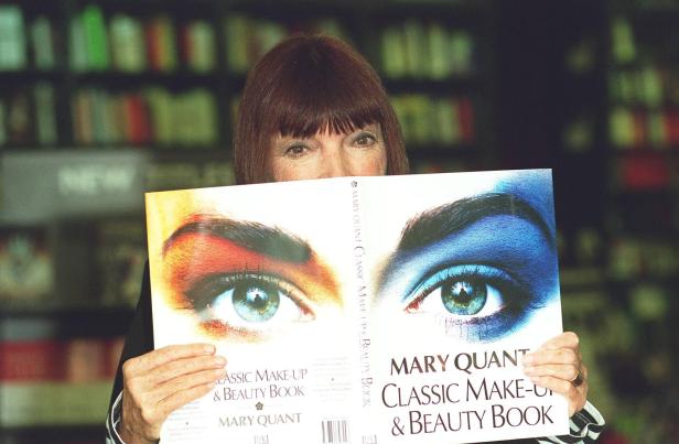 Mary Quant hält ihr Buch „Classic Make-up & Beauty Book“ vor ihr Gesicht.