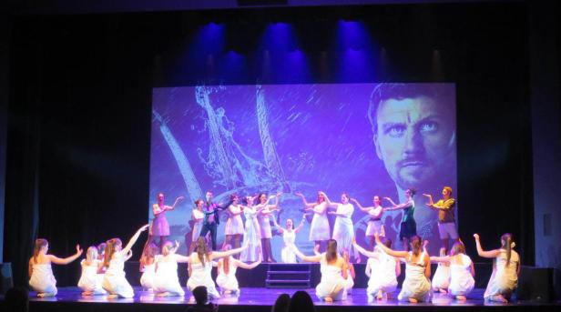 Eine Tanzaufführung mit einer Projektion von Poseidon im Hintergrund.