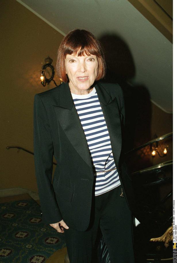 Mary Quant in einem gestreiften Oberteil und Blazer vor einer Treppe.