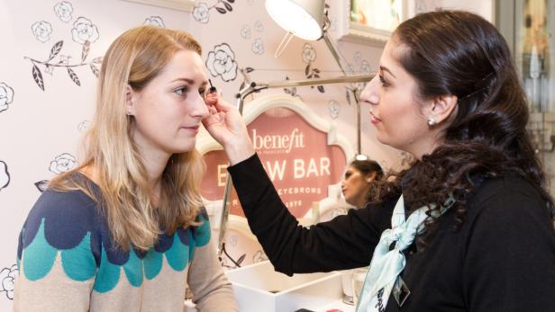 Eine Frau lässt sich in einer Benefit Brow Bar die Augenbrauen machen.