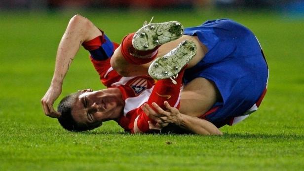 Ein Fußballspieler liegt verletzt auf dem Rasen.