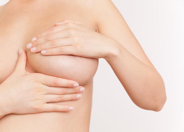 Eine Frau hält ihre Hände vor ihre Brust.