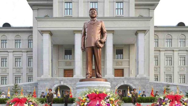 Eine Bronzestatue von Kim Il-sung vor einem großen Gebäude in Nordkorea.