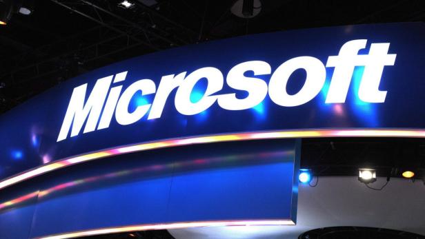 Das Microsoft-Logo auf einem blauen Stand mit Lichteffekten.